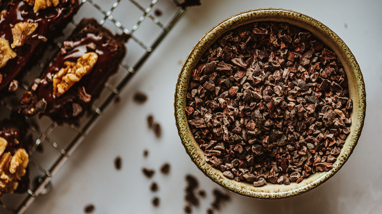 cacao nibs in bowl next to baking sheet