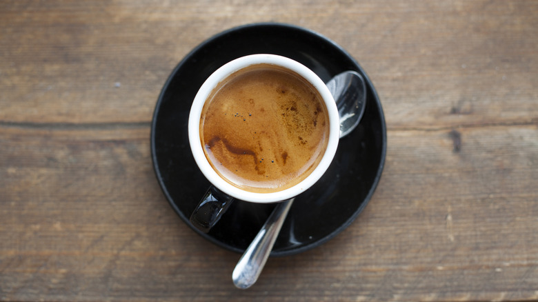 overhead shot of an espresso in a ceramic cup on a wood background