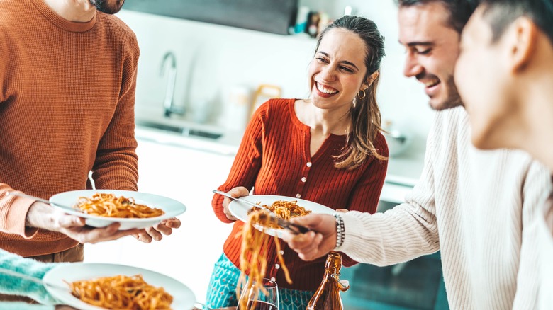 People eating spaghetti and smiling