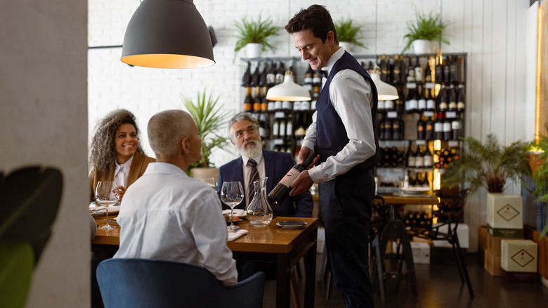 Server presenting bottle of wine