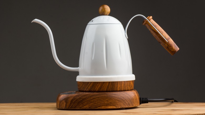 Gooseneck kettle pouring water into coffee grounds