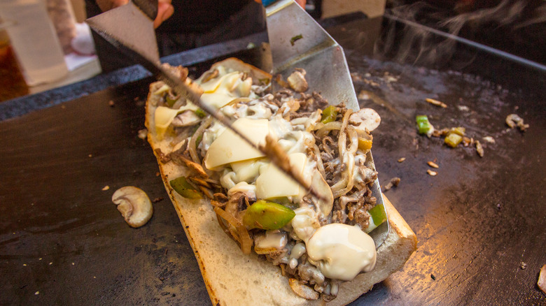 Spatulas mixed cheesesteak ingredients 