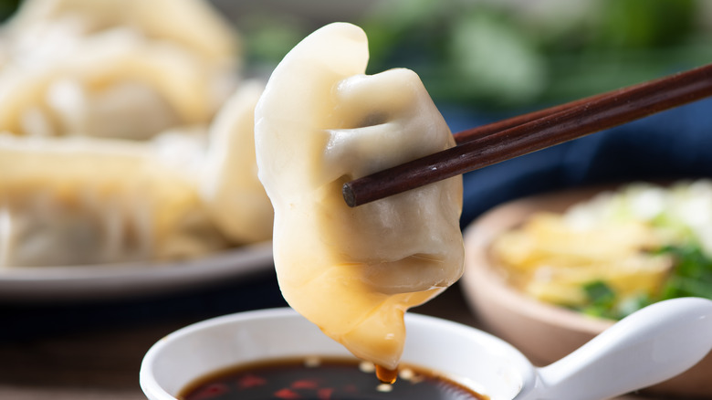 holding cooked dumpling with chopsticks