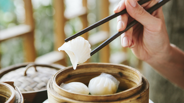 Hand holding prawn dumpling