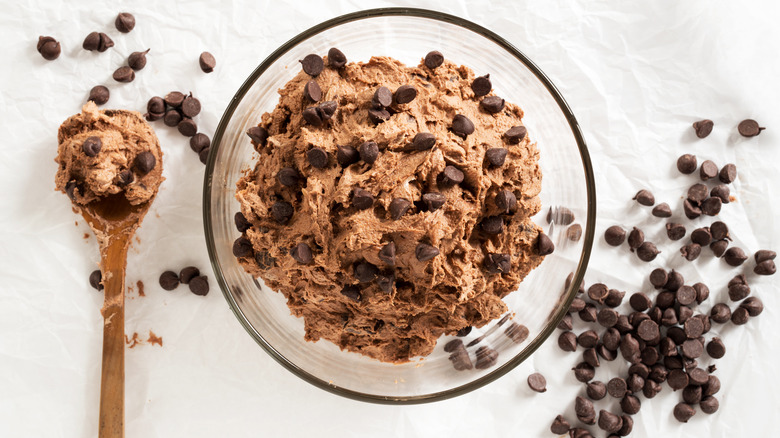 Cookie dough in a bowl, cookie dough in a spoon, and chocolate chips