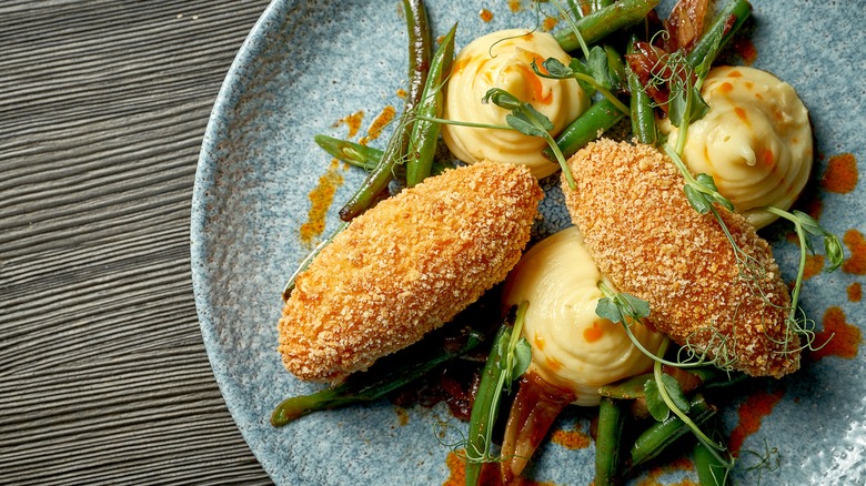 Chicken Kiev on plate with green beans