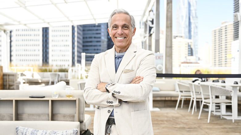 Geoffrey Zakarian smiling into the camera at a rooftop restaurant