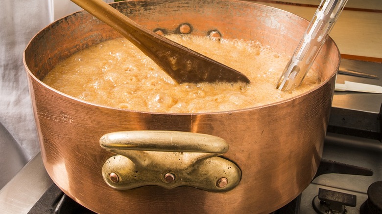 sugar and water boiling in pot with ladle