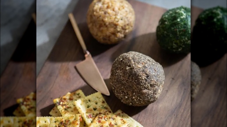 Cheese balls with different toppings presented on cheese board