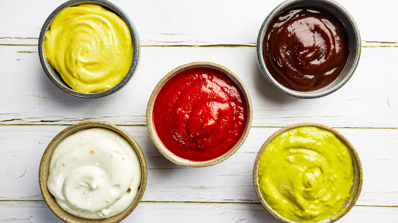 Various dipping sauces on white wood background