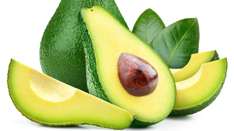 Avocado both sliced and whole with leaves