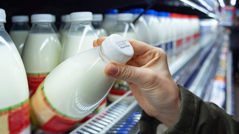 Person looking at expiration date on milk bottle