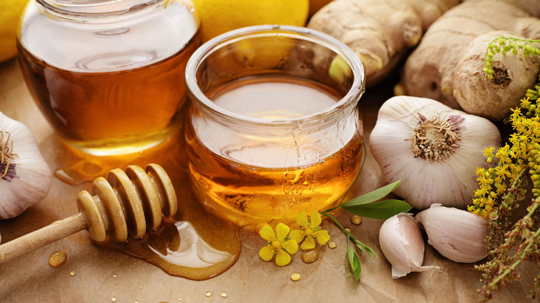 Honey jar next to whole garlic