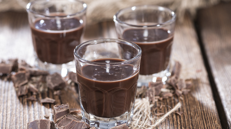 Three glasses of chocolate liqueur on wood table