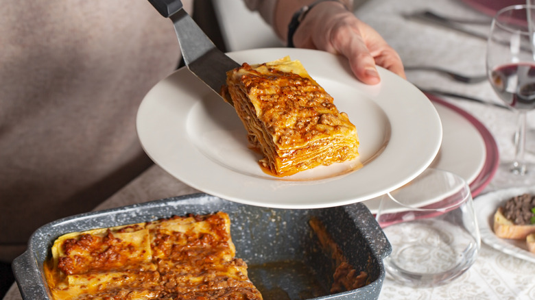 Woman serving homemade lasagna