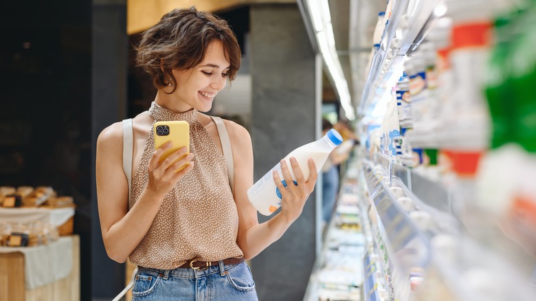 Person holding milk at store