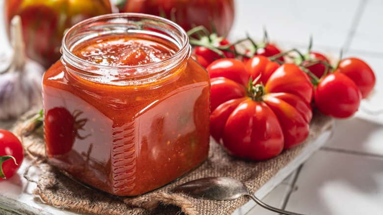 A jar of salsa with tomatoes