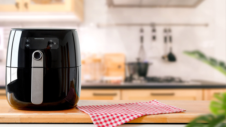 A black air fryer sitting on the kitchen counter