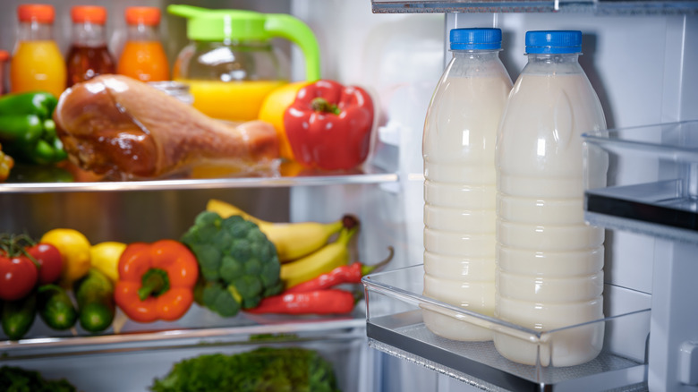 Bottles of milk in the fridge door.