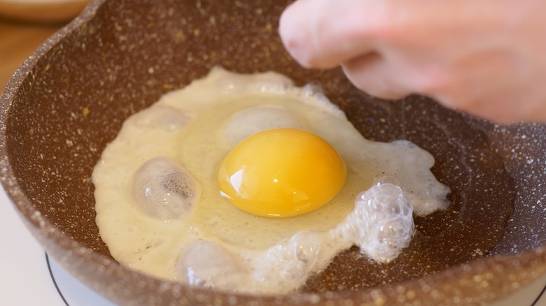 Person making sunny-side-up eggs