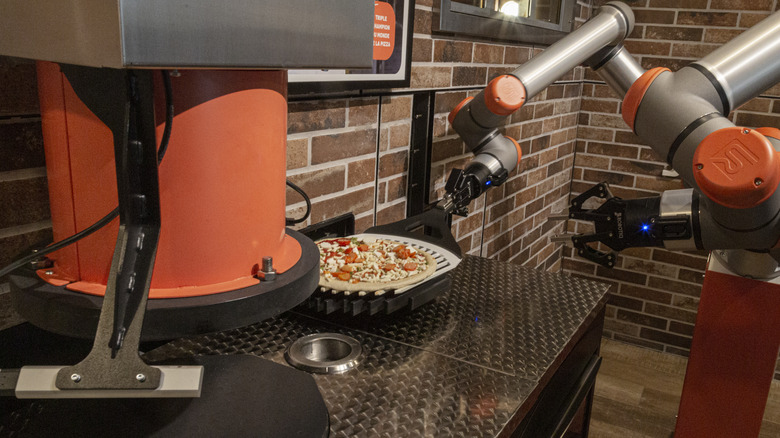 robotic arms making fresh pizza