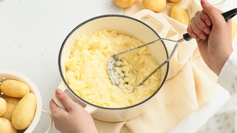 Mashing potatoes in pot