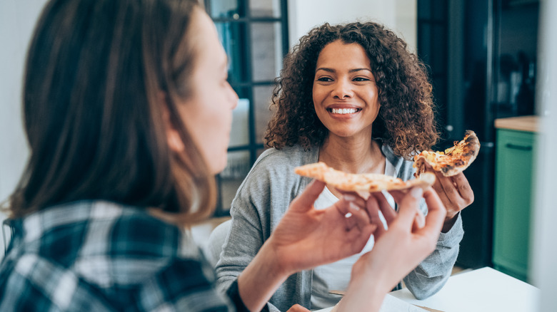 two women eating pizza