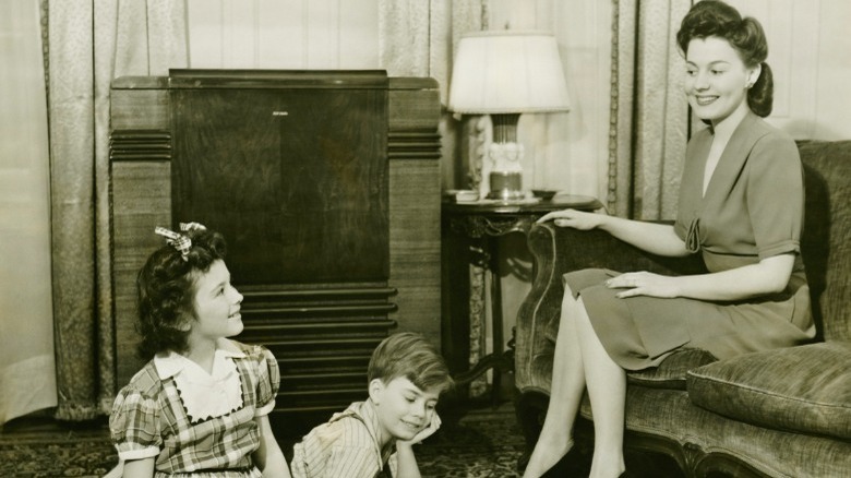 1930s mother sitting near two children
