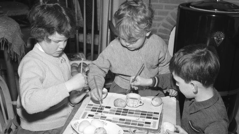young kids painting eggs