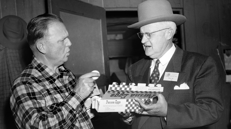 1950s men examining carton of eggs