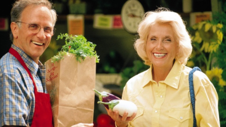 two people smiling with groceries