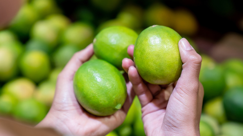 Person holding three limes