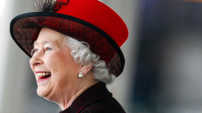 Queen Elizabeth smiling in red hat
