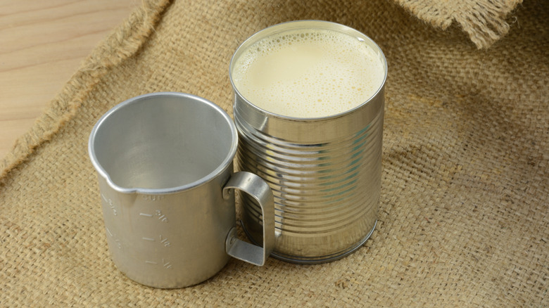 can of condensed milk with tin cup