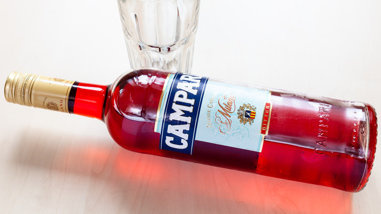 campari bottle lying beside glass