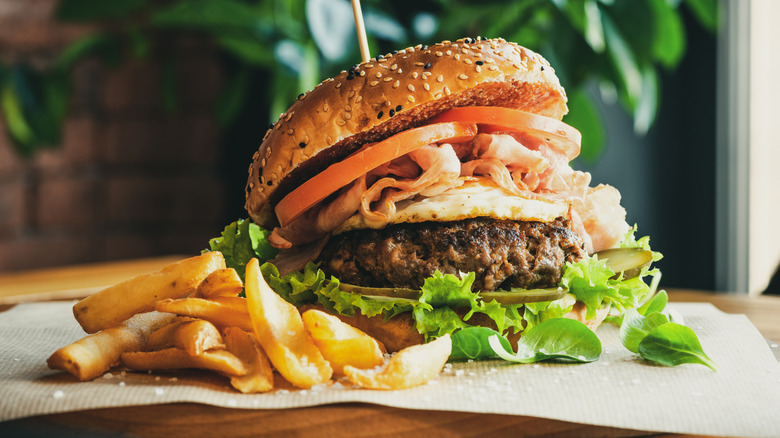 hamburger with lettuce next to French fries