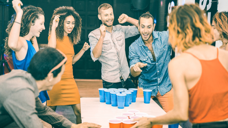 people playing beer pong and cheering