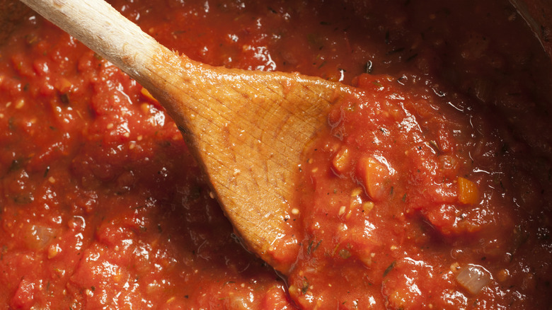 Red sauce with wooden spoon