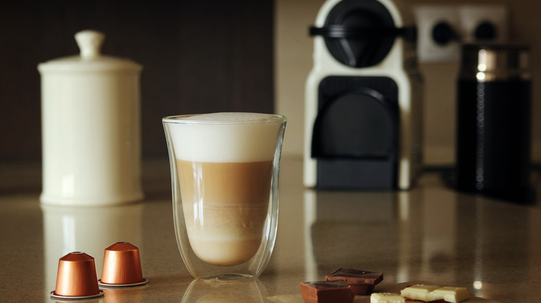 Cappuccino with a Nespresso machine in the background