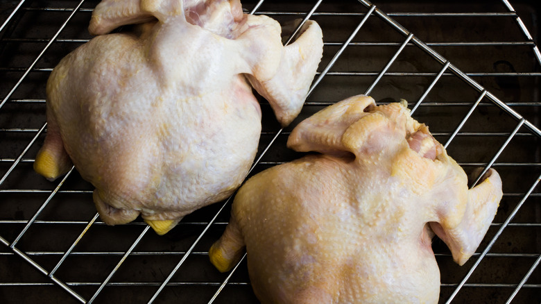 Raw Cornish hens on oven rack