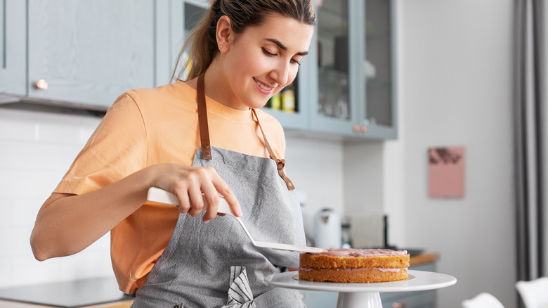 woman frosting a cake