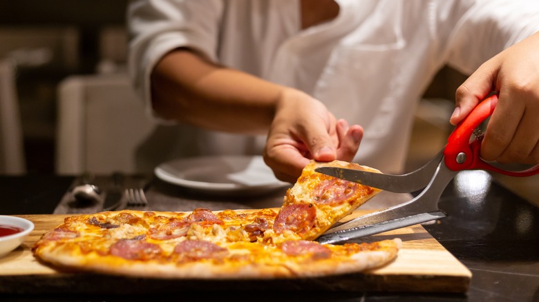 Cutting pizza with scissors