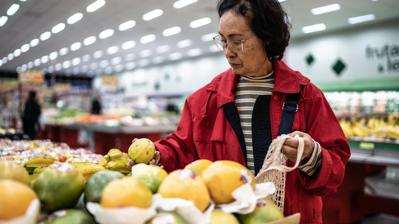 Senior woman shopping for guava fruits