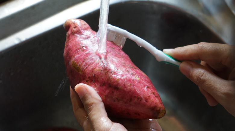 Man cleaning sweet potatoes