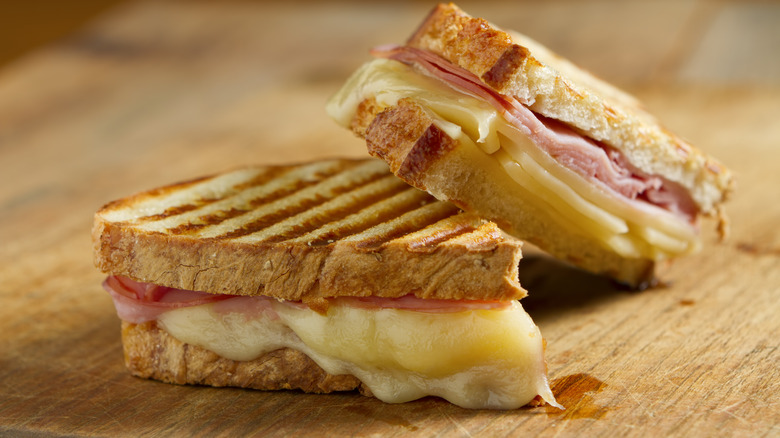 Grilled ham and cheese panini on a wooden surface