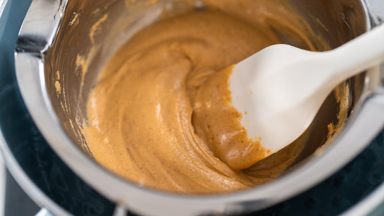 Metled fudge in a metal bowl with a white spatula