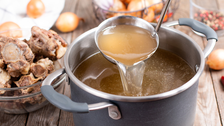 stock in a pot with a ladle