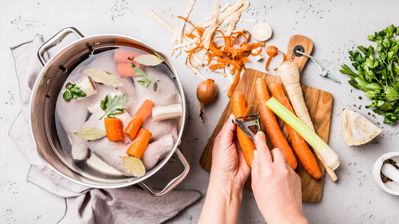 preparing a chicken stock with vegetables and leg quarters