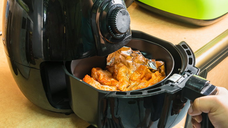 Chicken wings cooking in an air fryer