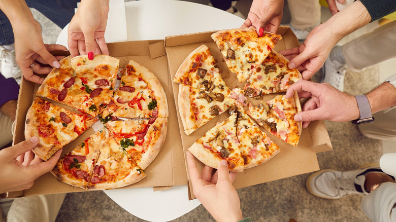 group enjoying two pizzas